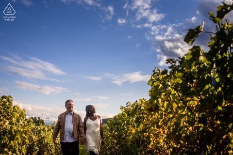 This lovely portrait from Chapareillan, France, captures a couple walking through the vineyards, beautifully framed by the vines, with the blue sky filling the top of the frame.