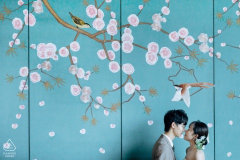In a private room at the Sheraton Hotel in Kaifeng, Henan, China, a couple shares a kiss in front of a mural featuring two magpies.