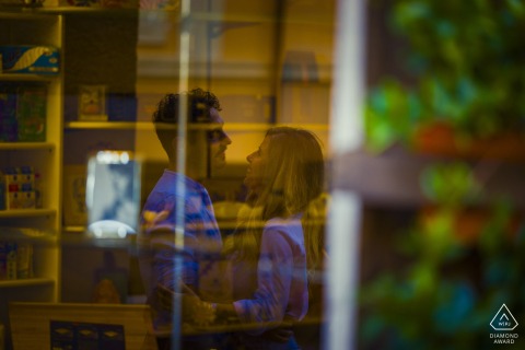 This indoor engagement portrait from Bolano, Italy, beautifully captures the couple standing face-to-face with their affectionate reflections mirrored in the glass. 