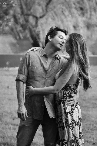 Adoring Embrace at Pine Lake Black and White Couple Portrait Session This vertical, black and white portrait at Pine Lake, GA, captures a couple adoring each other in a close embrace; she wraps him with both arms while he gives a tender, one-arm hug.