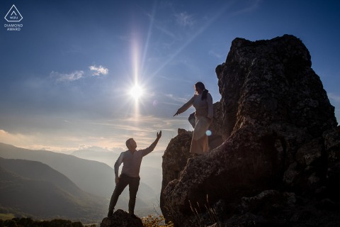 This striking portrait at La Pierre Percée, France, shows a couple silhouetted on a giant rock, playing a game of catch as she reaches down her hand and he reaches up, symbolizing connection and excitement.