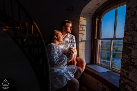 Sunset Glow and Togetherness by the Lighthouse in Chatham Couple Portrait Session Bathed in warm sunset glow, this Chatham, Massachusetts portrait shows the couple sitting peacefully by the lighthouse window, gazing toward the horizon, capturing their hope and togetherness.