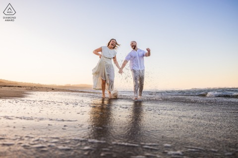 Saltwater Joy and Playful Laughter at Newcomb Hollow Beach Couple Portrait Session Barefoot on Newcomb Hollow Beach, this Wellfleet, Massachusetts portrait captures a couple's saltwater joy and playful laughter, reflecting their pure, unguarded happiness before marriage.