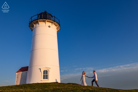 At Nobska Light in Falmouth, Massachusetts, a couple walks hand in hand atop the hill, symbolizing trust, partnership, and their journey together.
