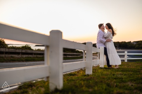 At Nobska Light in Falmouth, Massachusetts, a couple shares a gentle kiss by the roadside fence.