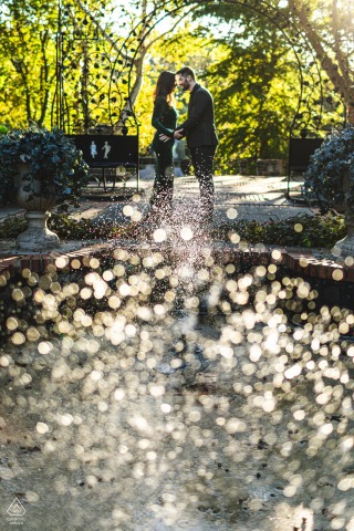 At the Hungarian Cultural Garden in Cleveland, OH, the couple is photographed through the fountains at sunset, with sunlight bursting behind them and illuminating the water droplets in the air.