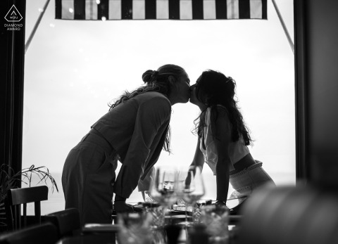 In a Saint Malo restaurant, the couple is silhouetted in the window, sharing a kiss with the sea in the background.