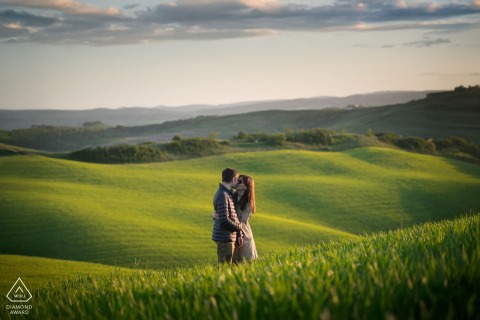 In Crete Senesi, Tuscany, a couple portrait features them surrounded by lush greenery and the rolling green hills, showcasing the region's stunning, scenic views.