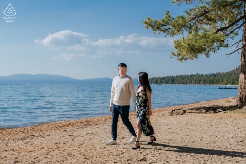 At South Lake Tahoe, CA, the couple walk hand in hand along the shore, with brilliant blue water and sky creating a stunning backdrop to their proposal. 