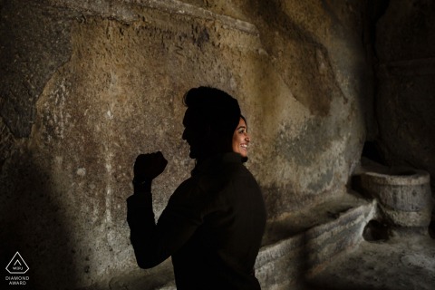 In Göreme, Nevşehir, Turkey, a Cappadocia pre-wedding portrait shows the couple standing back to back in profile—she is illuminated by sunlight, while he is fully silhouetted in shadow.
