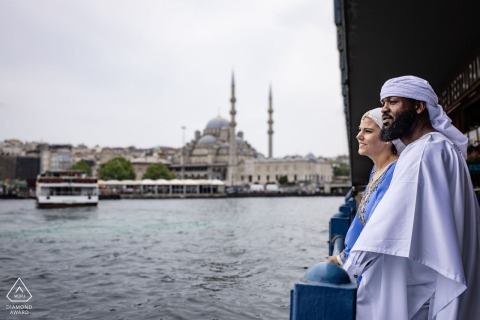 In Karaköy, Istanbul, a pre-wedding photo session features the couple standing under a bridge in profile, both gazing thoughtfully at the water.