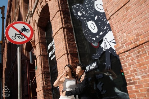 At a street corner on the Bund in Shanghai, China, he holds her close in a sweet pause amid the city's rush, captured from a low camera angle.