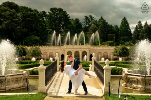 Engaged Couple Playful Dip in Sunshine at Longwood Gardens Philadelphia At Longwood Gardens in Philadelphia, the couple shares a playful dip in the sunshine amidst shimmering waters, radiating joy and a love that flows endlessly.