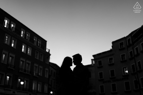 Engaged Couple Silhouetted Face to Face in Urban Venice Portrait Session In Venice, Italy, the couple stands face to face, silhouetted in black and white between urban buildings, creating a striking and romantic city portrait.