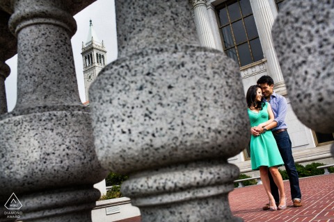Engagement Portrait of a Couple at UC Berkeley With Stone Balusters At UC Berkeley in Northern California, an engagement portrait captures the couple through old-world stone balusters in the foreground, adding timeless architectural charm to the scene.