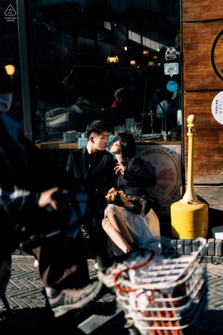 Dashilan Street Engagement Photo: Couple Kissing with Passing Bicycle in Foreground On Dashilan Street in Beijing, China, a couple shares a kiss as a bicycle passes by in the foreground of their portrait.