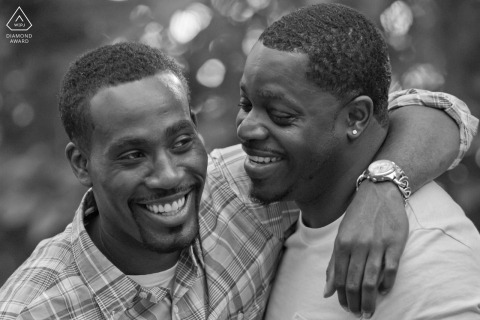 Engaged Couple Laughs in Outdoor Pine Lake Portrait A couple laughs together in a close black-and-white outdoor portrait in Pine Lake, Georgia.