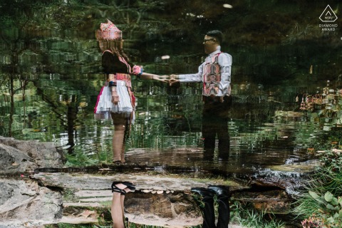 Artistic portrait at UNCC Botanical Gardens, showing a couple’s reflection upside down in water, creating a visually intriguing and creative engagement photo surrounded by natural beauty.
