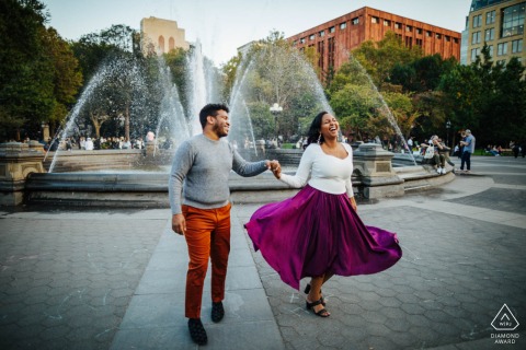 Couple dances and twirls together in the heart of Manhattan, New York, center framed with a city fountain behind them, capturing the vibrant energy and romance of NYC. 