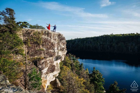 Couple embraces adventure in Hudson Valley, New York, standing boldly near the edge of rocky cliffs. Their carefree spirit and daring love are captured in this dramatic, scenic engagement portrait.