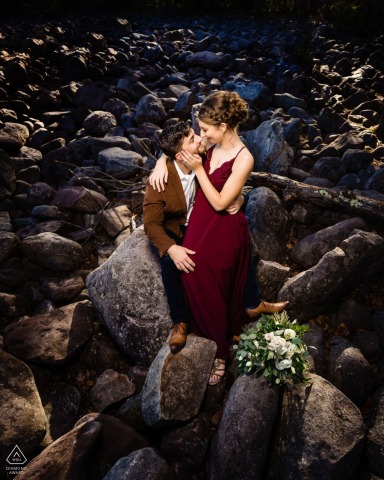 Tucked among the stones in Philadelphia, the couple intertwines hands and exchanges soft smiles, finding stillness and connection, captured from a high view in a tall vertical portrait.