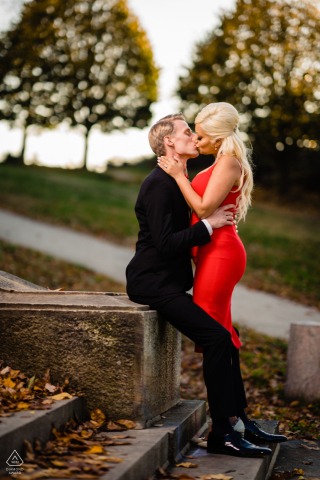 The couple shares a quiet kiss on the stone steps of the Philadelphia Museum of Art, surrounded by colorful autumn leaves, embodying a peaceful and romantic fall portrait.