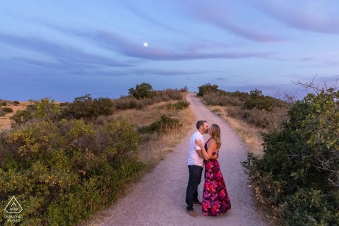 Newlyweds Share Romantic Kiss Standing On A Quiet Backcountry Road Near Home In Highlands Ranch This newlywed couple shares a romantic kiss while standing on a quiet backcountry road near their home in Highlands Ranch, Colorado, surrounded by the peaceful beauty of the countryside.
