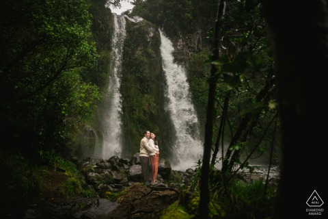 This couple poses gracefully by a cascading waterfall in Taranaki, New Zealand, capturing a romantic engagement portrait set against the powerful and lush natural beauty of the island’s landscape.