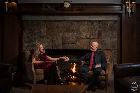 Engaged Couple Luxuriates In Warmth Of Fire At The Iconic Stanley Hotel In Estes Park An engaged couple is seen luxuriating in the warmth of a fire and their love at the iconic Stanley Hotel in Estes Park, Colorado, during a cozy indoor session.