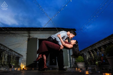 Partner Lifts Bride Beneath Twinkling Lights At Chateau Des Senechaux In Rural Bourdeilles France Portrait He lifts her gently as they hold each other beneath twinkling lights at Château des Sénéchaux in Bourdeilles, Dordogne, sharing a tender and romantic engagement portrait in rural France.