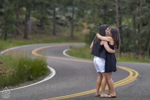 Engaged Couple Shares Romantic Kiss On A Sleepy Mountain Road Within Scenic Golden Colorado Rockies Sharing a romantic kiss on a quiet, sleepy mountain road in Golden, Colorado, this engaged couple celebrates their upcoming wedding surrounded by the peaceful and scenic beauty of the Rockies.