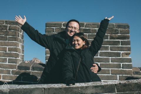Celebrating their devotion at the Mutianyu Great Wall in Beijing, China, this engaged couple shares a romantic embrace that symbolizes a love destined to last for ten thousand years.