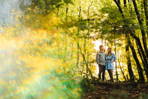 A moment of calm glows through the forest in Ecoche, Loire, France, where the couple is wrapped in a prism of light during their tranquil and artistic engagement photoshoot.