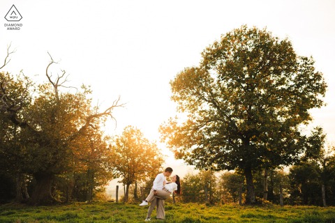 Soft golden light reveals a gentle and effortless connection between the engaged couple as they explore the beautiful outdoor landscape of Ecoche, Loire, France, during their romantic sunset session.