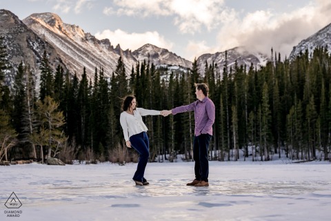 Dancing On Frozen Bear Lake In Rocky Mountain National Park, Colorado, The Couple Spins Amid Snow-Draped Winter Beauty The couple dances atop the frozen surface of Bear Lake in Rocky Mountain National Park, Colorado, sharing a joyful spin on the ice with towering pines and snow-draped peaks circling their winter celebration.