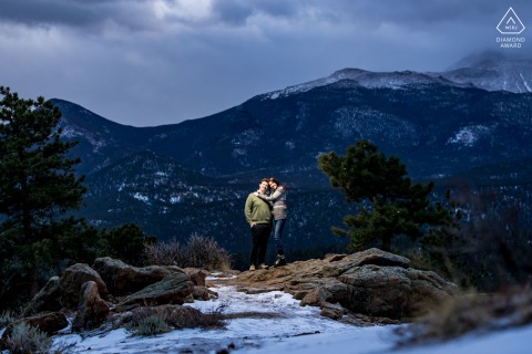 With twilight colors softly filling the sky in Rocky Mountain National Park, Colorado, the couple poses together, their bodies outlined against the fading light for a romantic and serene portrait.