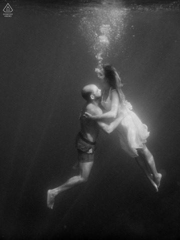 Immersed in the crystal-clear waters of Sestri Levante, Liguria, Italy, the couple shares an underwater portrait session a few days before their wedding, their embrace floating gracefully beneath the surface.