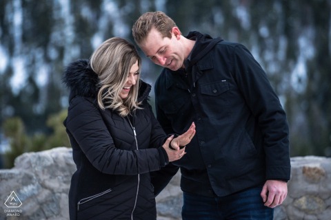 A couple shares a joyous session by the serene shores of South Lake Tahoe, California, their connection highlighted by the stunning backdrop of mountains and crystal-clear water during their engagement session.
