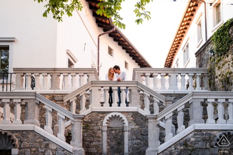 A couple hugs on a grand staircase at Stanjel Castle in Slovenia, their engagement portrait framed by beautiful stone steps and old-world architectural details that add a romantic, timeless atmosphere.