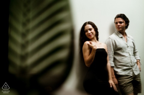 A couple poses near tropical foliage at Chable Riviera Maya, their engagement portrait framed by blurred leaves, capturing a modern and editorial style against the lush backdrop.