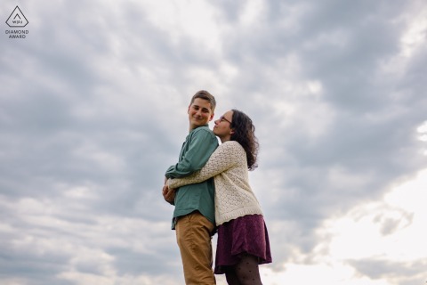 Shared between two lovers, an intimate and complicit interaction unfolds before a dramatic, cloudy sky in Angles sur l'Anglin, France, captured just before the arrival of a seasonal storm.