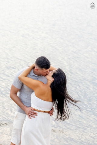On a beautiful autumn afternoon at Usina do Gasômetro in Porto Alegre, Brazil, a couple poses on the shores of Lake Guaiba to create a lovely and seasonal image.