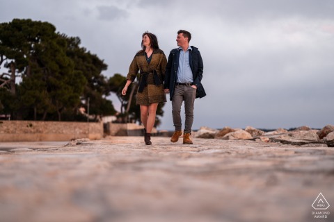 An adventurous couple walks hand in hand through the scenic landscapes of Croatia, enjoying a quiet and romantic stroll during their destination engagement session.