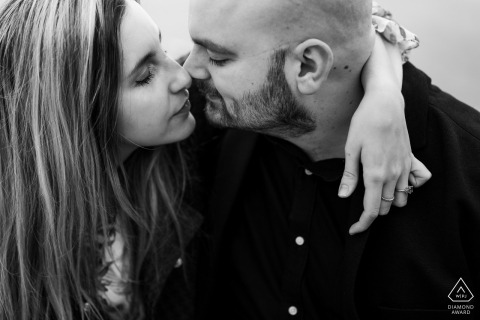 This intimate, close-up portrait of a couple highlights their joyful expressions and connection during a professional engagement photoshoot held in the beautiful and historic coastal city of Trieste, Italy.