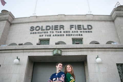 In Chicago, Illinois, the engaged couple pose in front of Soldier Field, with his home team pride and her Packers fandom adding playful rivalry to the portrait.