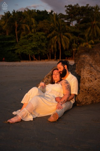 In Costa Rica, the couple poses in front of the ocean at sunset, framed by glowing skies, calm waves, and a relaxed romantic setting there.