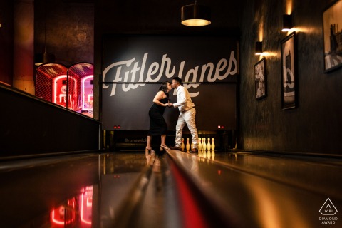 In Philadelphia, the couple shares a playful portrait at the bowling lanes, where warm light and reflections add a fun, cinematic feel to the scene.