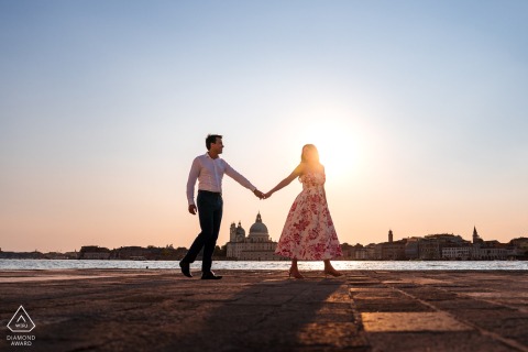 In Venice, Italy, the couple walks together in warm golden hour light, creating a romantic portrait with soft tones, graceful movement, and timeless Italian atmosphere.