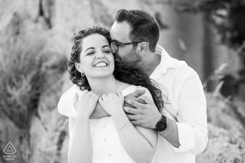 Black and white pre-wedding engagement portrait of a groom-to-be holding his future bride closely in Jaén, Andalucía, Spain.