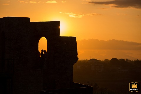 At Castello Aragonese, Ortona, Chieti, Abruzzo, Italy, the couple stands by the tower as the sun sets, a beautiful end to the day.